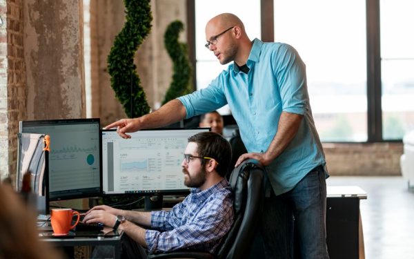 Team members collaborating on data analysis in a modern office in St. Louis.