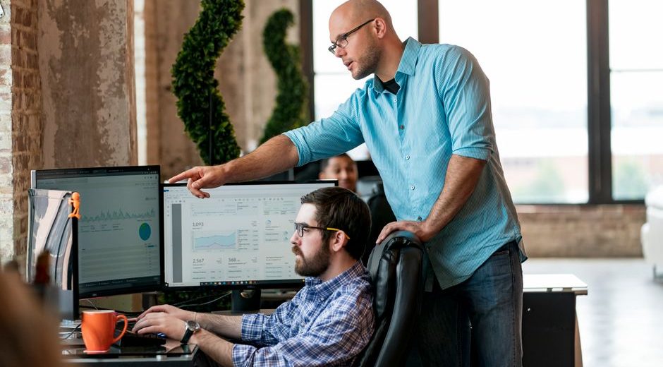 Team members collaborating on data analysis in a modern office in St. Louis.